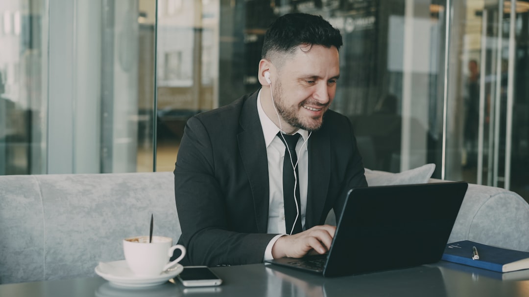 Man in suit working on laptop in cafe