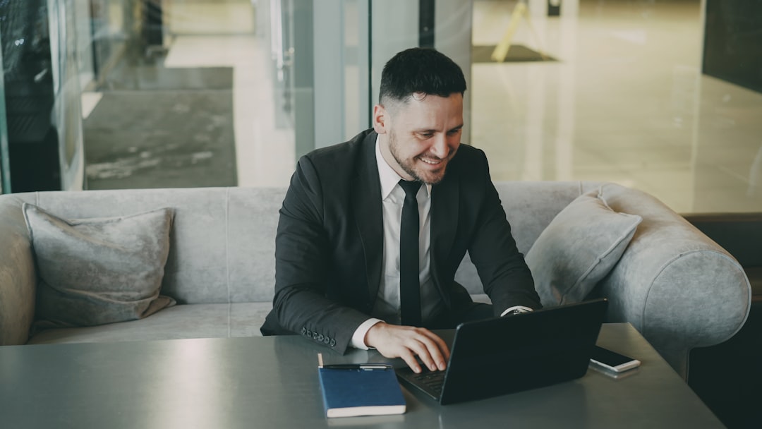 Man in suit working on laptop at a table.